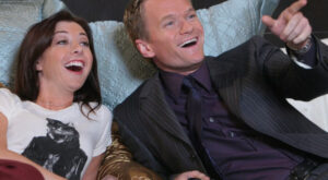 lily-alyson-hannigan-and-barney-neil-patrick-harris-watching-tv-in-bed-and-laughing-in-how-i-met-your-mother