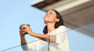 Satisfied,Adult,Woman,With,Coffee,Cup,Breathing,Fresh,Air,On