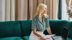 Attractive,Middle,Aged,Woman,Using,Laptop,And,Taking,Notes,While