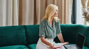 Attractive,Middle,Aged,Woman,Using,Laptop,And,Taking,Notes,While