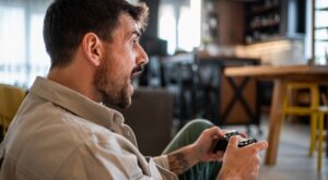 Young,Man,Engrossed,In,Playing,Video,Games,,Holding,A,Wireless