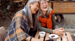 Pretty,Senior,Asian,Woman,Puts,Head,On,Laughing,Friend,Shoulder