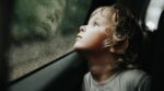 Thoughtful,Little,Blond,Baby,Boy,Seated,In,Car,Backseat,Looking