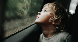 Thoughtful,Little,Blond,Baby,Boy,Seated,In,Car,Backseat,Looking